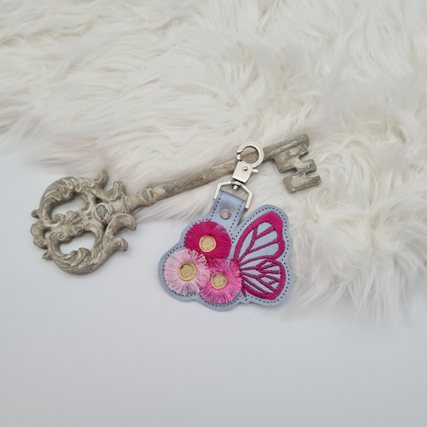 Taschenanhänger / Taschenbaumler Schmetterling mit Blumen grau/pink